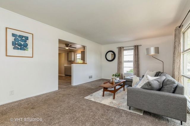 living room featuring baseboards, visible vents, and light colored carpet