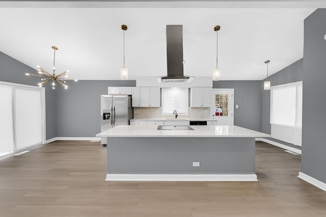 kitchen featuring hardwood / wood-style flooring, decorative backsplash, range hood, a large island, and stainless steel fridge with ice dispenser