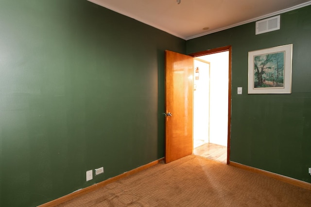 unfurnished room featuring carpet flooring, baseboards, visible vents, and ornamental molding