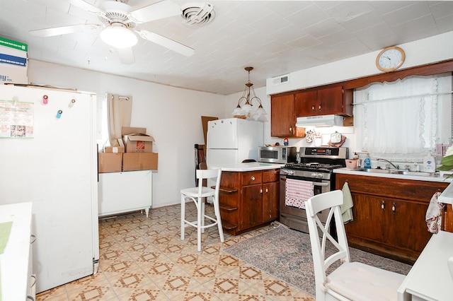 kitchen featuring visible vents, a sink, ventilation hood, stainless steel appliances, and light countertops