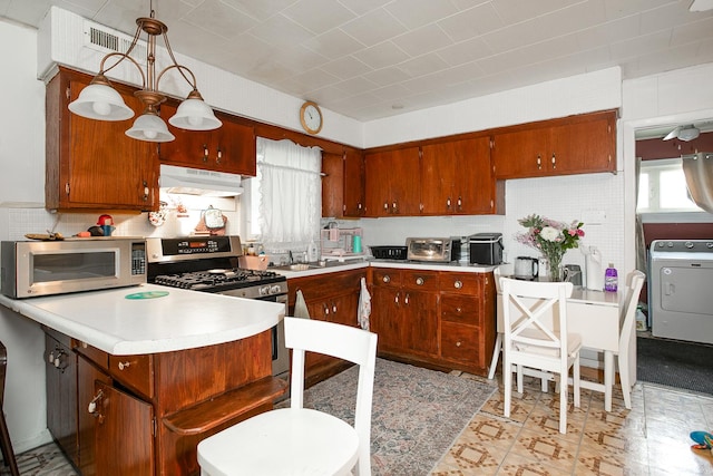 kitchen featuring range hood, appliances with stainless steel finishes, light countertops, washer / dryer, and a healthy amount of sunlight