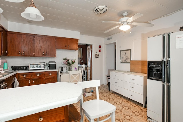 kitchen with visible vents, white refrigerator with ice dispenser, and light countertops