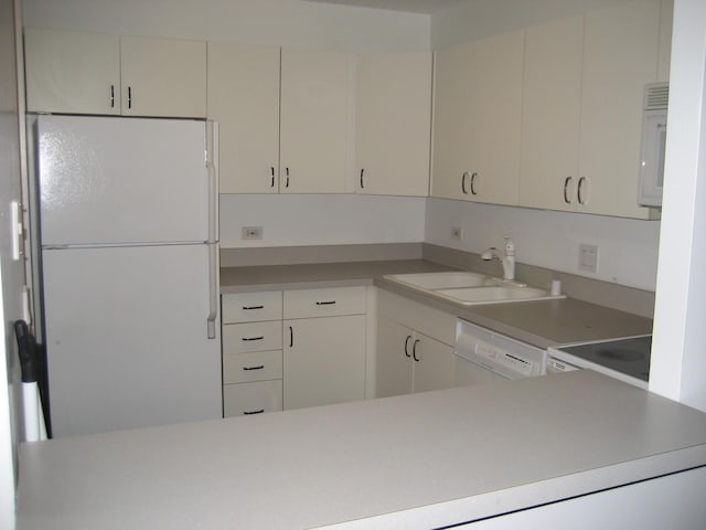 kitchen featuring white cabinetry, sink, and white appliances