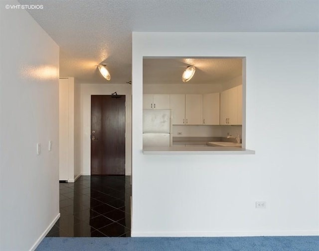 kitchen with white fridge, a textured ceiling, and dark carpet