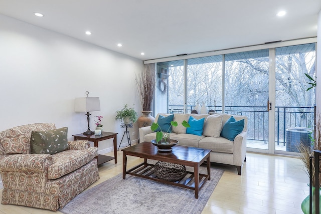 living room with floor to ceiling windows and light wood-type flooring