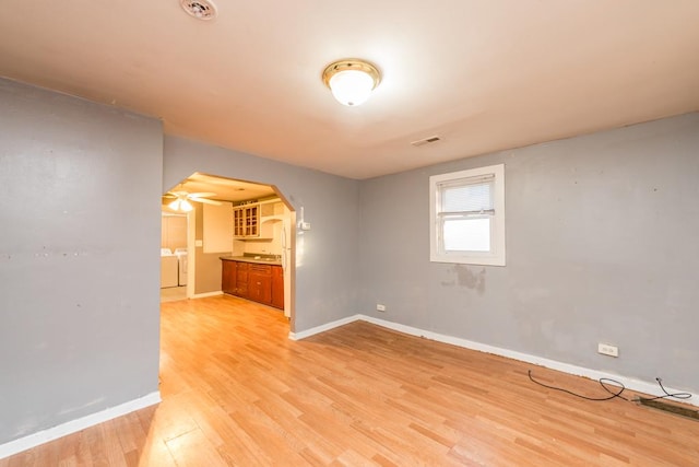 spare room featuring ceiling fan, washer and dryer, and light wood-type flooring