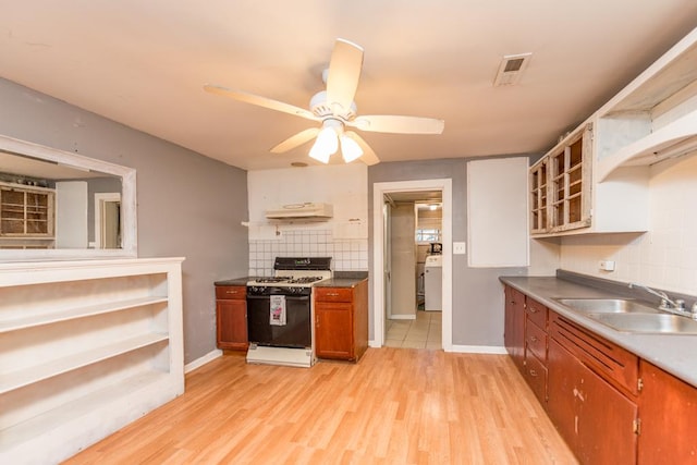 kitchen featuring sink, light wood-type flooring, white gas stove, and backsplash