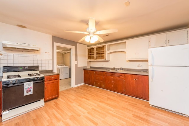 kitchen with white appliances, backsplash, washing machine and dryer, light wood-type flooring, and extractor fan