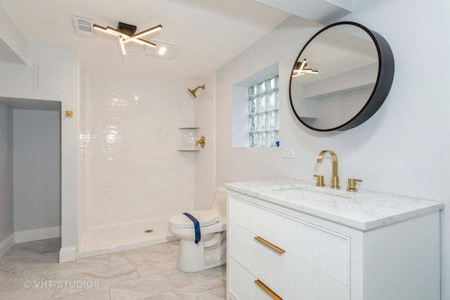 bathroom featuring toilet, vanity, and a tile shower