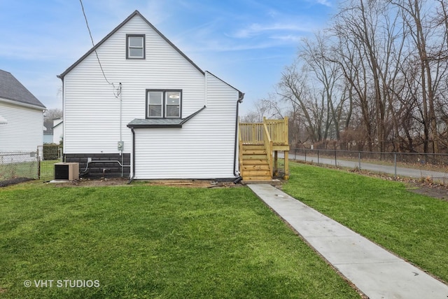 rear view of house with a lawn, central AC, and a wooden deck