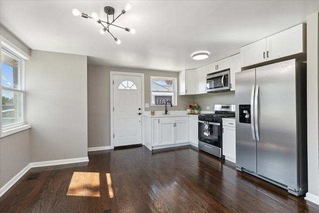 kitchen featuring white cabinetry, an inviting chandelier, dark hardwood / wood-style floors, and appliances with stainless steel finishes