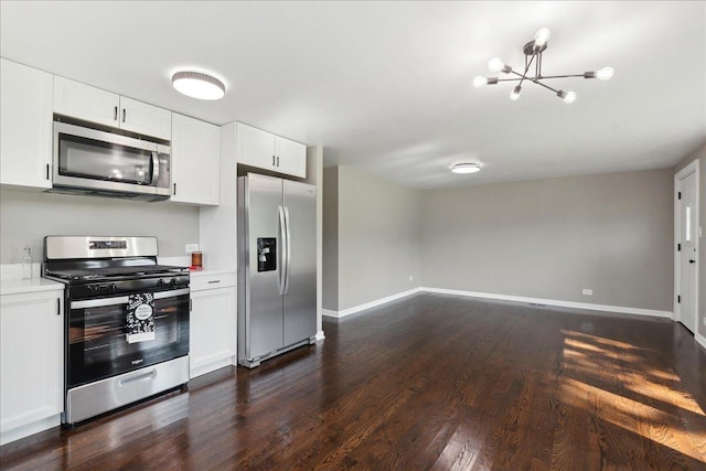 kitchen featuring an inviting chandelier, stainless steel appliances, white cabinetry, and dark hardwood / wood-style floors