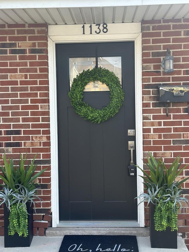 view of exterior entry featuring brick siding