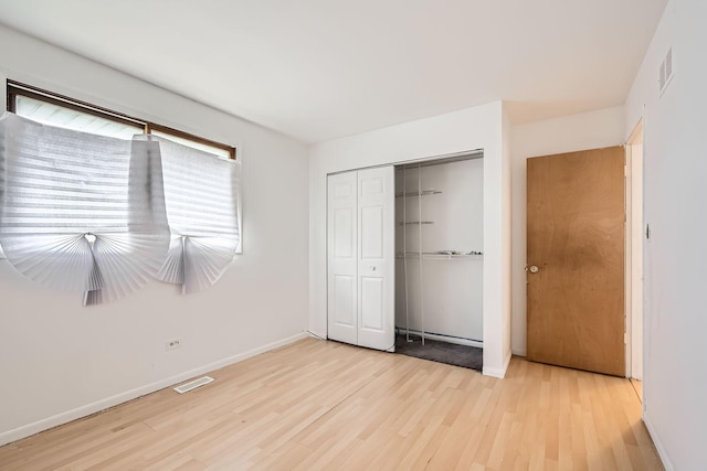 unfurnished bedroom featuring light hardwood / wood-style floors and a closet