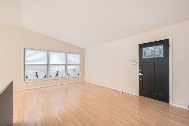 foyer with light hardwood / wood-style floors and lofted ceiling