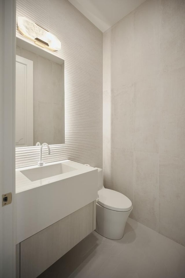 bathroom featuring tile walls, vanity, tile patterned flooring, and toilet