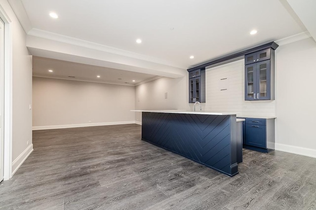 bar featuring crown molding, dark hardwood / wood-style flooring, and sink