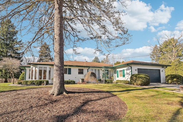 ranch-style house with a garage and a front lawn