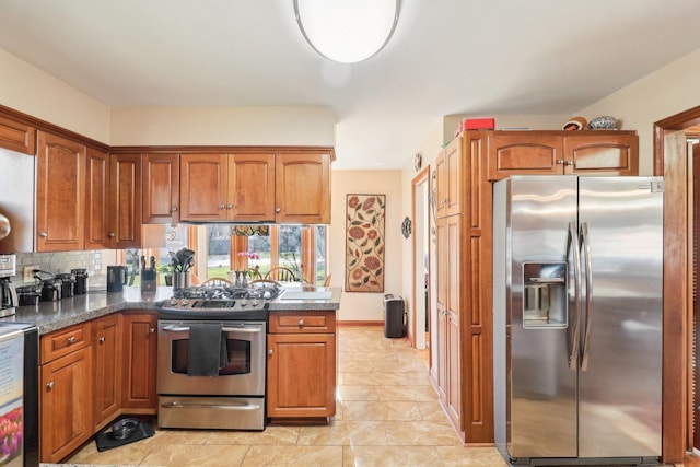 kitchen featuring light tile patterned flooring, stainless steel appliances, dark stone counters, and tasteful backsplash