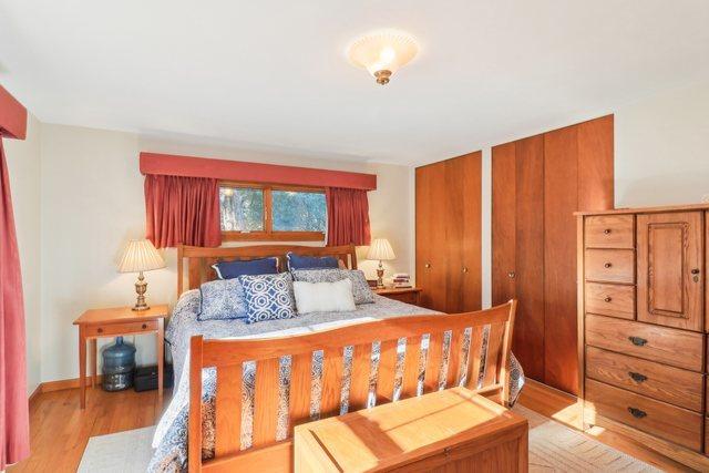 bedroom featuring light hardwood / wood-style flooring and multiple closets