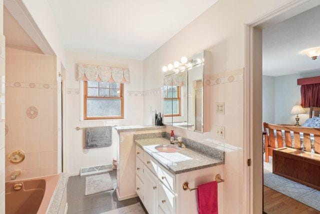 bathroom featuring hardwood / wood-style floors, vanity, and a bath