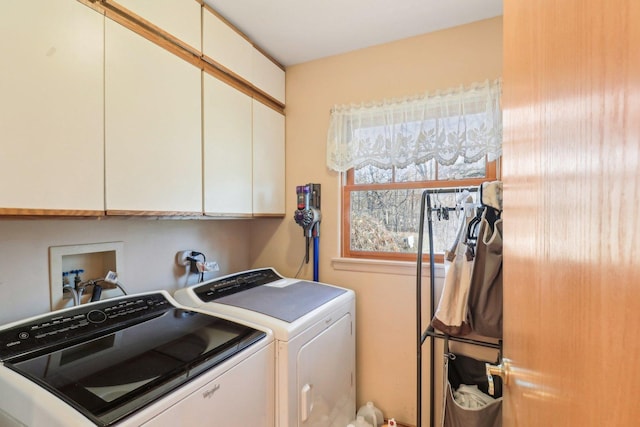 clothes washing area with cabinets and independent washer and dryer