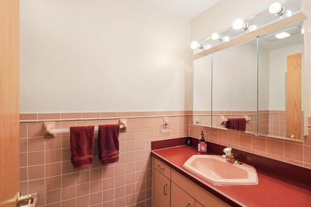 bathroom featuring vanity and tile walls