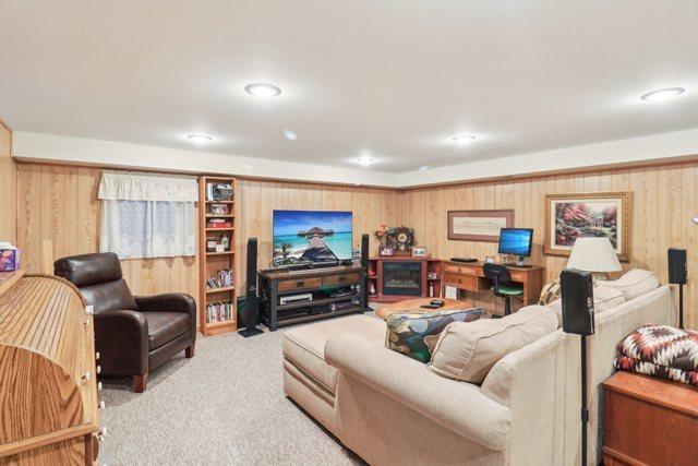 living room with wood walls and light carpet