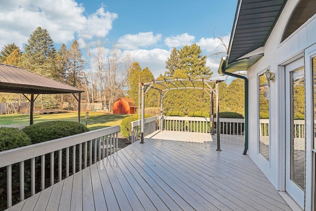 wooden terrace with a gazebo, a storage unit, and a yard