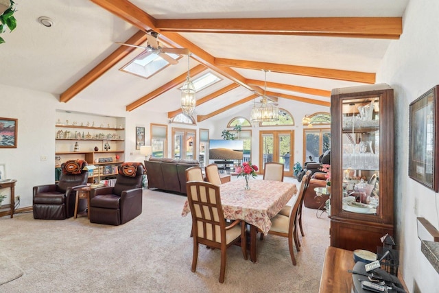 dining space featuring carpet, french doors, lofted ceiling with beams, ceiling fan with notable chandelier, and built in features