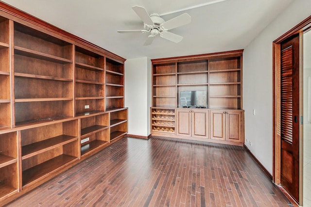 unfurnished living room with dark hardwood / wood-style flooring and ceiling fan