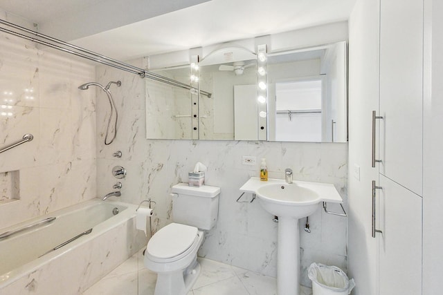 bathroom with toilet, tiled shower / bath, and tile walls