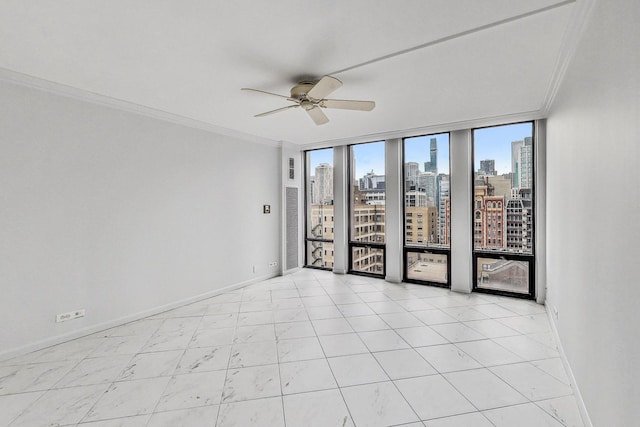 spare room featuring ceiling fan, expansive windows, and ornamental molding