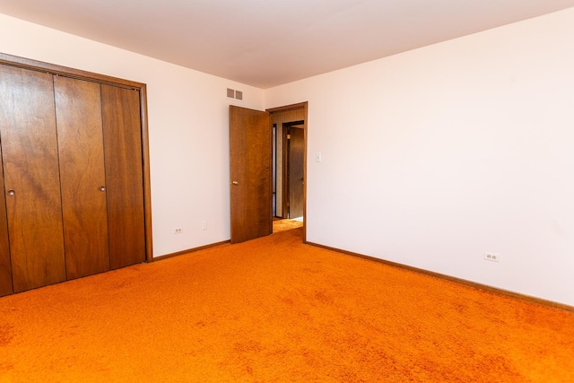 unfurnished bedroom featuring carpet flooring and a closet