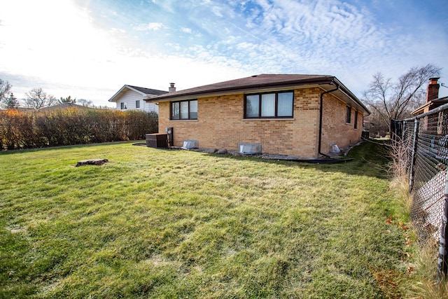 back of house featuring a lawn and central AC unit