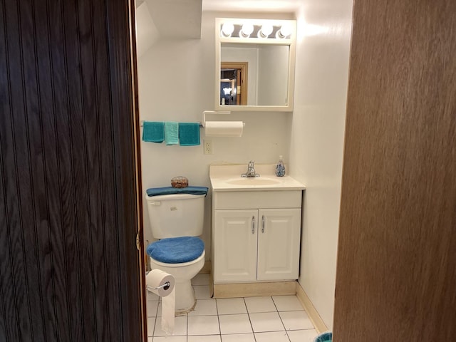 bathroom with tile patterned flooring, vanity, toilet, and lofted ceiling