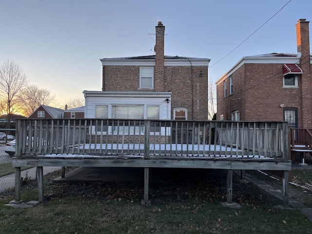 back house at dusk with a wooden deck