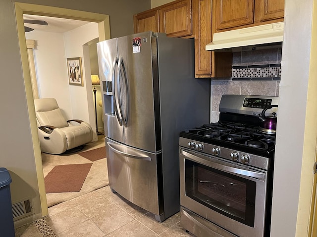 kitchen with decorative backsplash, light tile patterned floors, and stainless steel appliances