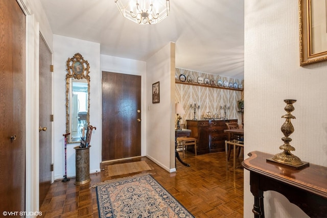 entryway featuring a notable chandelier and dark parquet flooring