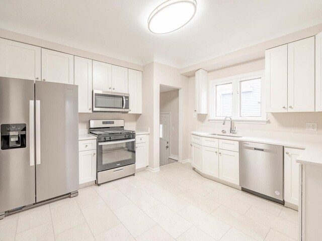 kitchen featuring light wood-type flooring, stainless steel appliances, white cabinetry, and sink