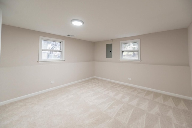 empty room featuring light carpet, electric panel, and plenty of natural light