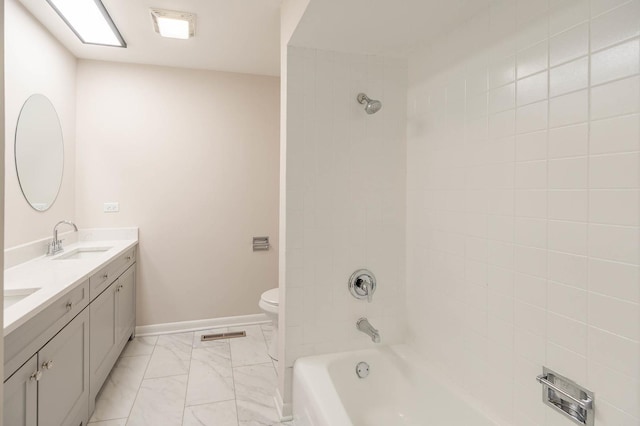 full bathroom featuring tiled shower / bath combo, toilet, and vanity