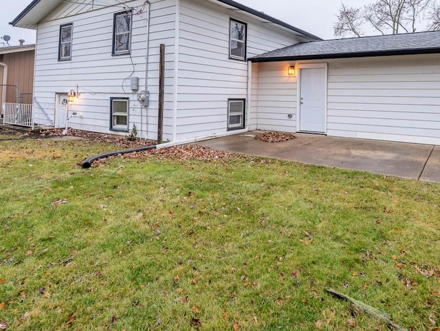 back of property with a yard and a patio area