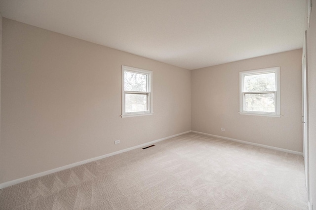 unfurnished room with a wealth of natural light and light colored carpet