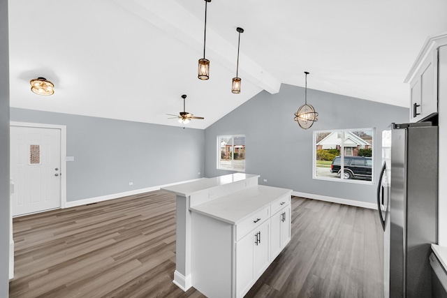 kitchen with white cabinetry, vaulted ceiling with beams, dark hardwood / wood-style flooring, and stainless steel fridge