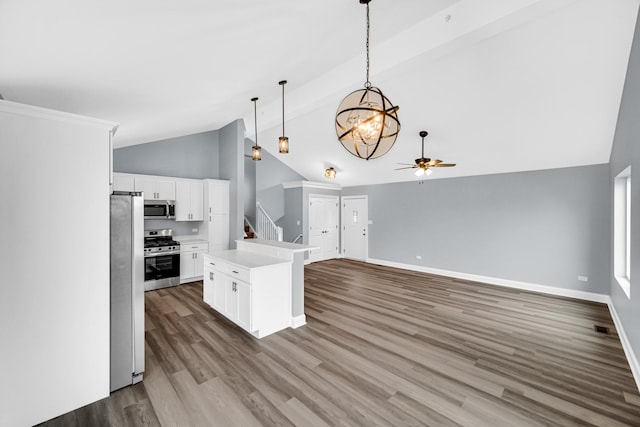 kitchen with a center island, hardwood / wood-style floors, white cabinetry, decorative light fixtures, and stainless steel appliances