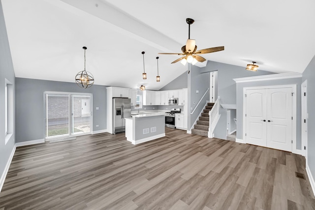 kitchen featuring white cabinetry, a center island, lofted ceiling, and stainless steel appliances