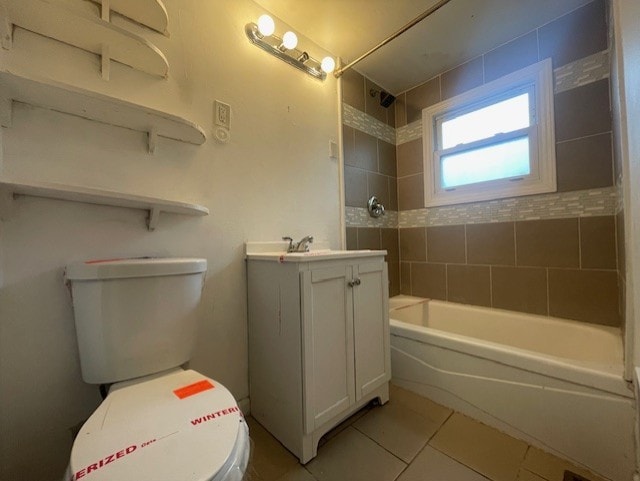 full bathroom featuring toilet, vanity, tile patterned floors, and tiled shower / bath