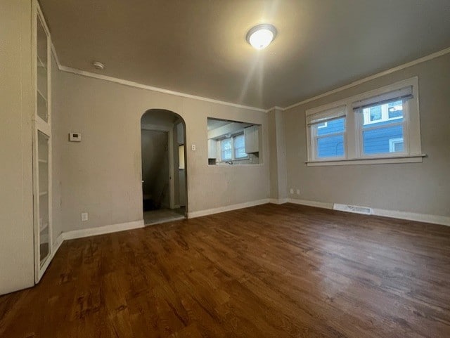 spare room featuring dark hardwood / wood-style flooring and ornamental molding