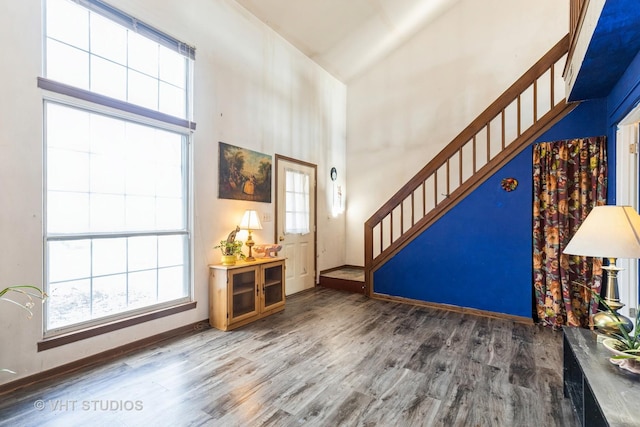 entrance foyer with a towering ceiling and hardwood / wood-style floors